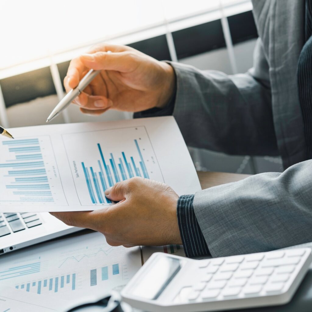 Expert analysant des graphiques financiers et documents lors d’une mission d’expertise